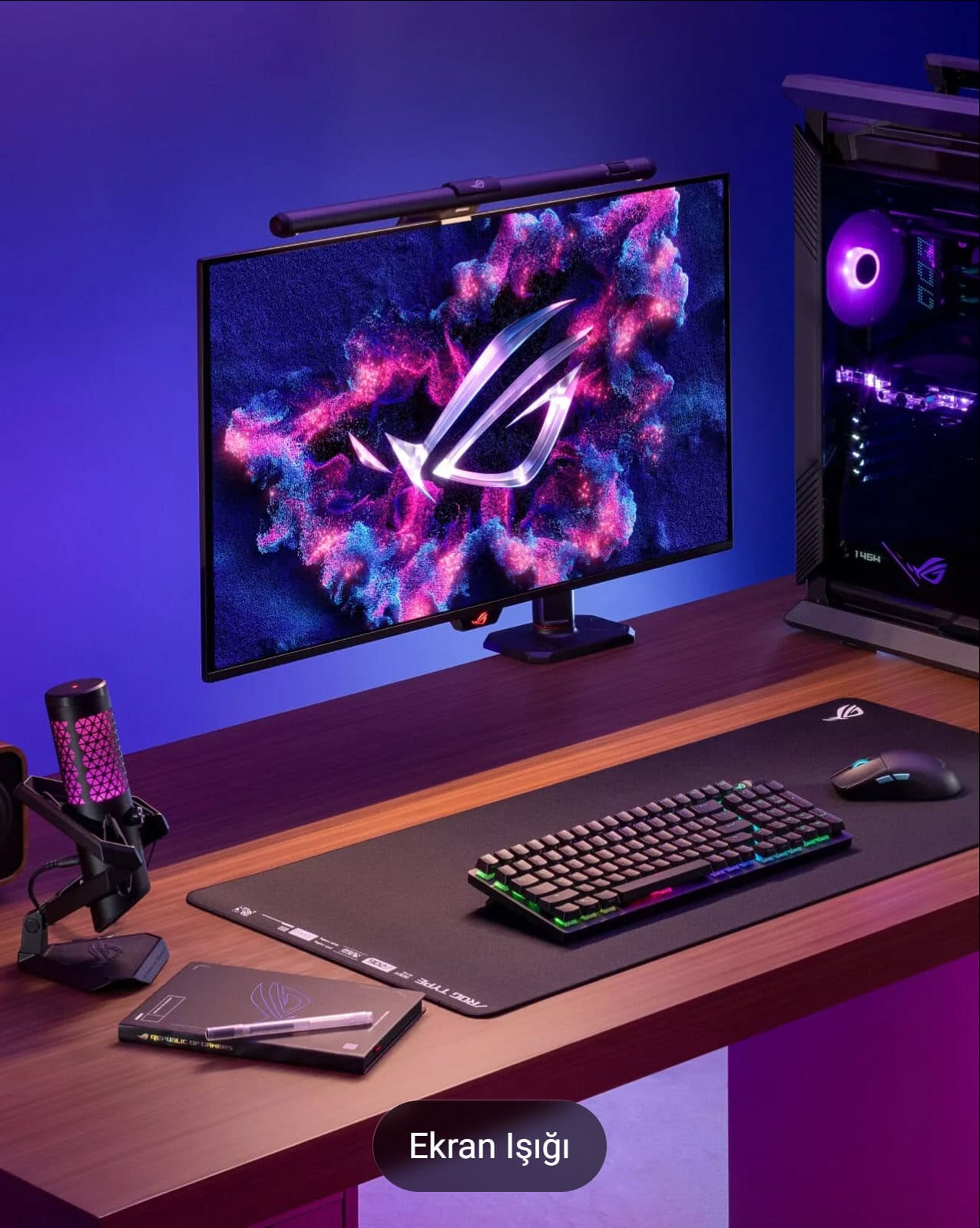 Yüksek çözünürlüklü ASUS ROG oyun monitörü ve gamer ekipmanları aydınlatılmış masa düzeni, bilgisayar oyuncuları ve e-spor tutkunları için ideal.