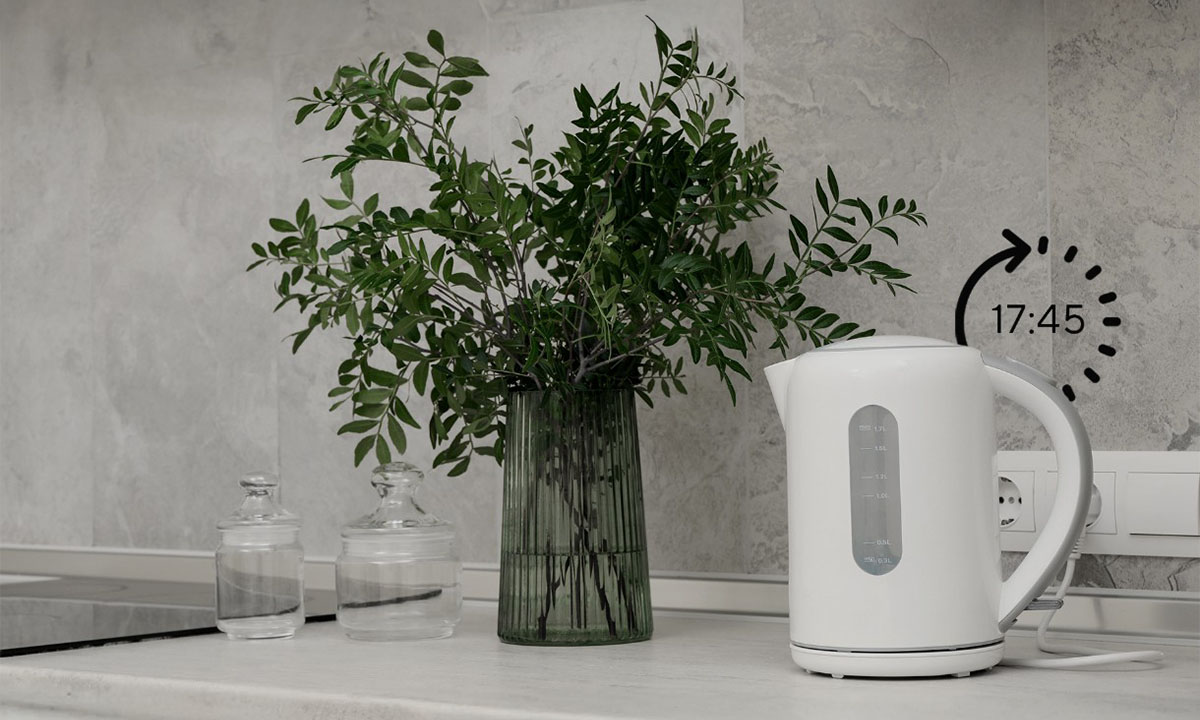 Yeşil bitki ve şeffaf cam şişeler ile beyaz elektrikli cezve, modern mutfak dekorasyonu. Saat ve zaman gösterimiyle gömme prizler duvarda.