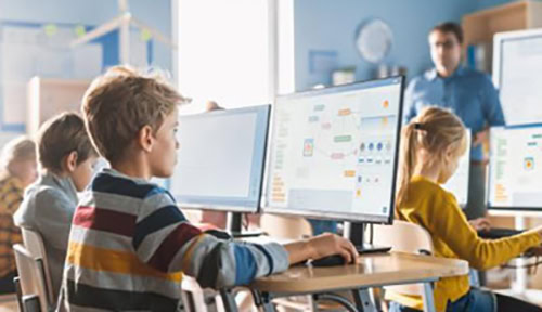 Öğrencilerin bilgisayar başında sınıf ortamında eğitim aldığı bilgisayar dersleri, kodlama ve programlama öğrenme, teknolojik gelişmeler ve STEM eğitimleri detaylı görsel.