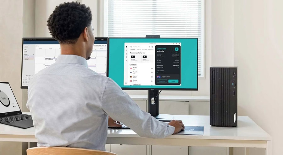 Yazılım geliştirme ve bilgisayar kullanımıyla ilgili ofis ortamında çalışan kişi, iki monitör ve modern bilgisayar donanımıyla çalışıyor.